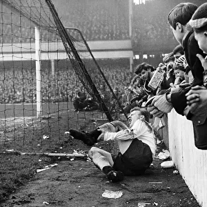 Spur's Terry Dyson lies in agony after colliding with the concrete wall at Upton Park after a challenge by a West Ham Player 1964
