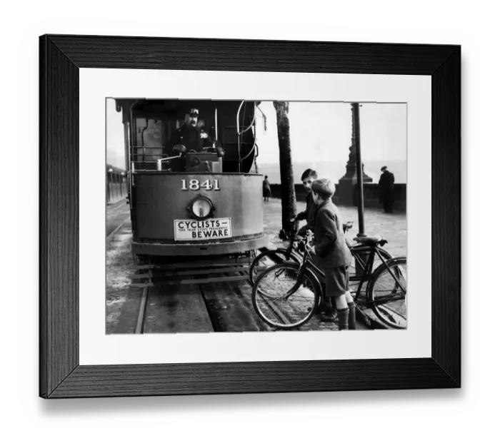 Framed Print : Children on bicycles crossing in front of a tram Framed Print : Children on bicycles crossing in front of a tram