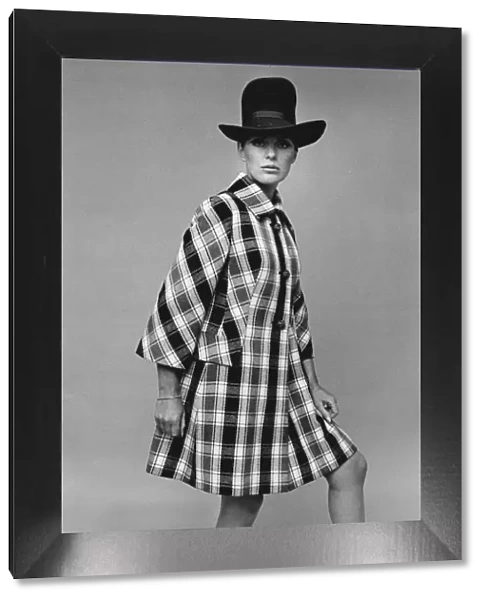 Model wearing large hat and checked coat