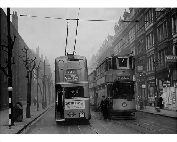 A trolleybus passes a tramcar in Grays Inn Road, London in 1938