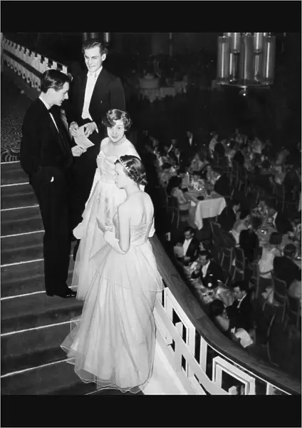 Debutantes and their escorts chat on the stairs at Queen Charlot
