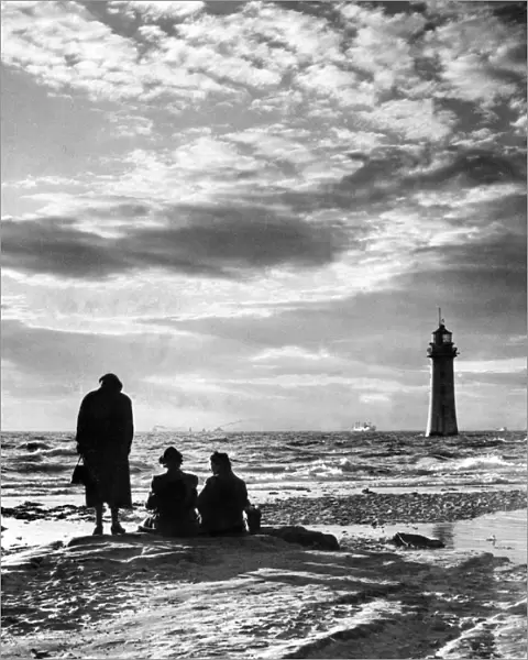New Brighton Lighthouse, with silhouetted figures watching