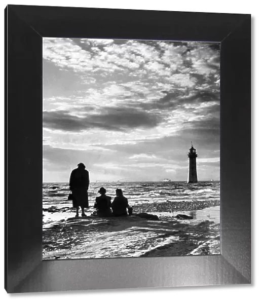 New Brighton Lighthouse, with silhouetted figures watching