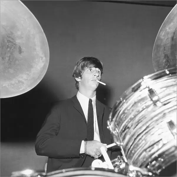Ringo Starr smokes a cigarette at the drums as the Beatles perfo