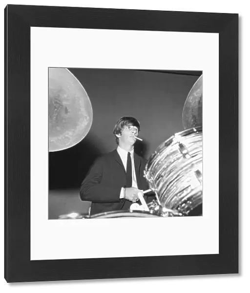 Ringo Starr smokes a cigarette at the drums as the Beatles perfo