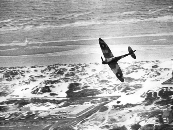An RAF Spitfire flies over the dunes of Dunkirk
