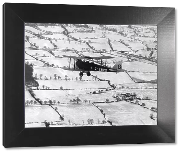 A Tiger Moth over snow-covered countryside, 1927