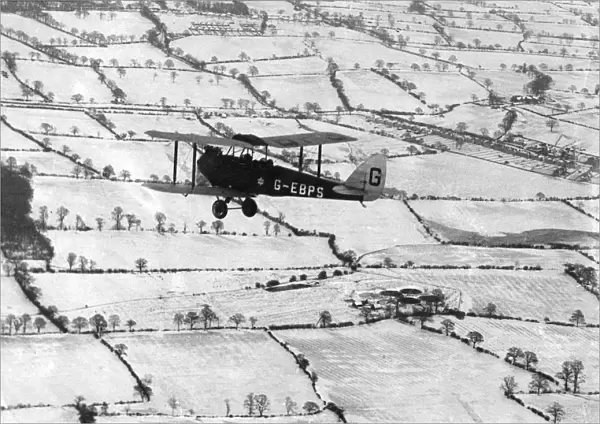 A Tiger Moth over snow-covered countryside, 1927
