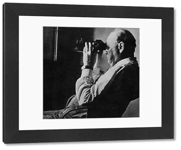 Sir Winston Churchill looking through a set of binocular