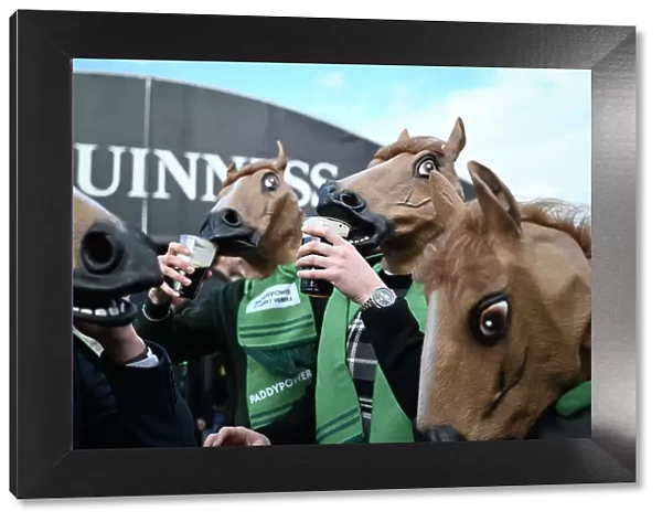 Fans get in the Cheltenham mood by sipping on their pints of Guinness while wearing a horse mask Cheltenham Festival week