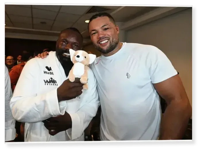 Print : SoulofSport. Derek Chisora fight week behind the scenes 2024. Fight day at the 02, Derek and Joe Joyce embrace in Joe's changing room with a gift from Joe's mum Print : SoulofSport. Derek Chisora fight week behind the scenes 2024. Fight day at the 02, Derek and Joe Joyce embrace in Joe's changing room with a gift from Joe's mum
