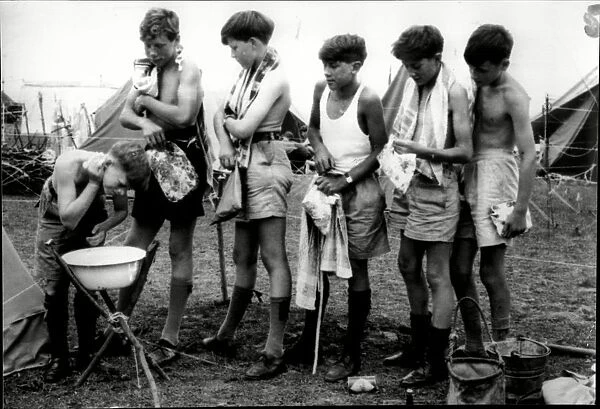 Boys scouts line up to wash in a bowl