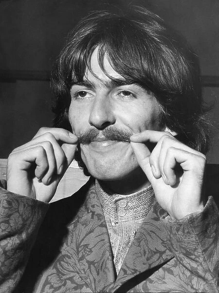 George Harrison tweaks his moustache at EMI studios for rehearsa