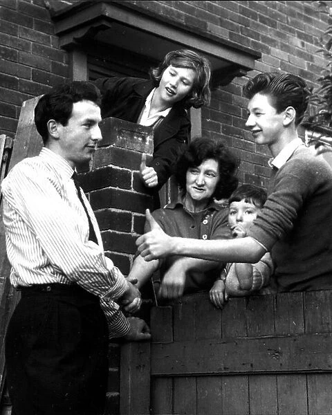 Huddersfield footballer Mike O'Grady is congratulated by neighbours at his Leeds home after being capped for England