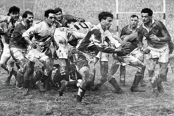 John Williams, the England scrum half pictured holding the ball is hardly distinguishable from his challenger Rees Stephens, the Welsh forward in the mud