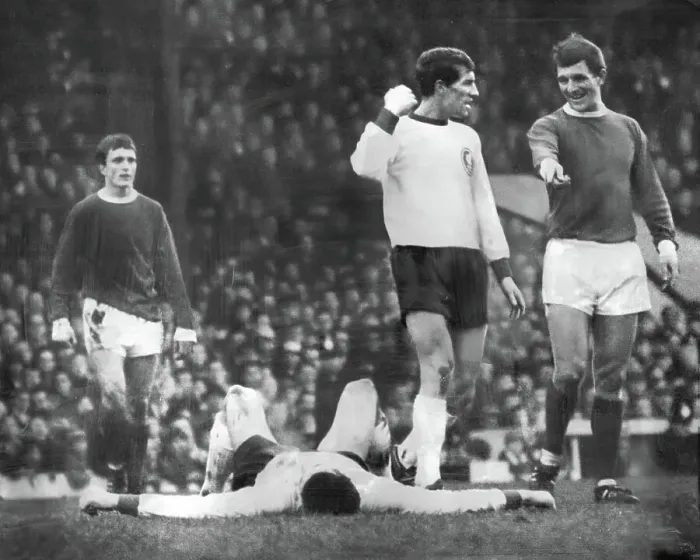 Framed Print : Manchester United's David Herd, as Willie Stevenson demonstrates how Liverpool captain Ron Yeats has been felled by George Best 1966 Framed Print : Manchester United's David Herd, as Willie Stevenson demonstrates how Liverpool captain Ron Yeats has been felled by George Best 1966