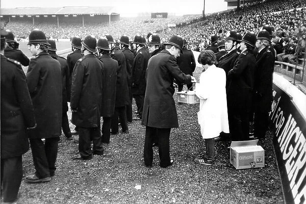 A police officer buys snacks from a vendor during the 1982 FA Cup quarter-final at Stamford Bridge