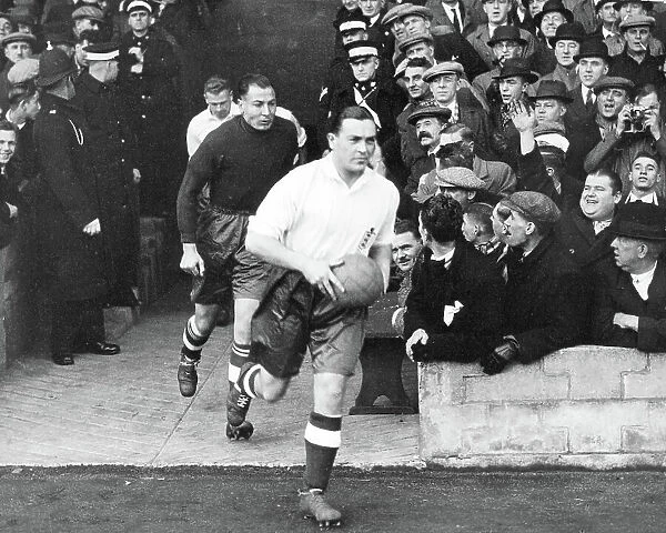 Sam Barkas, captain of the England Football Team, leads them out to play Wales at Middlesborough 1937