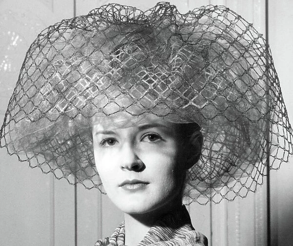 Sixties hat fashion. Fashion model Bridget Daly wearing a net hat by Lachasse, 1962
