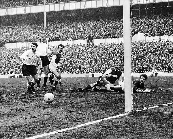 Spur's Laurie Brown watches his shot hit the post as Arsenal's keeper Jim McClelland and centre-half Ian Ure look on