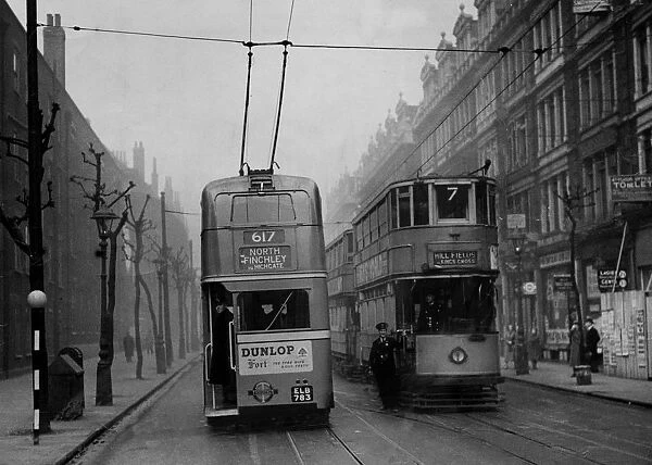 A trolleybus passes a tramcar in Grays Inn Road, London in 1938