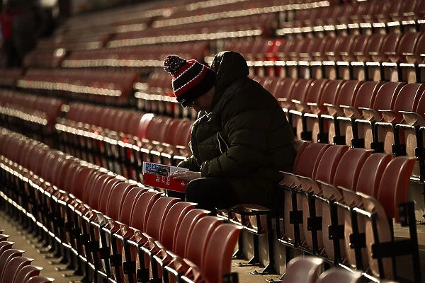 Welcome to Wrexham AFC - an early fan sitting reading the clubs programme hours before the game