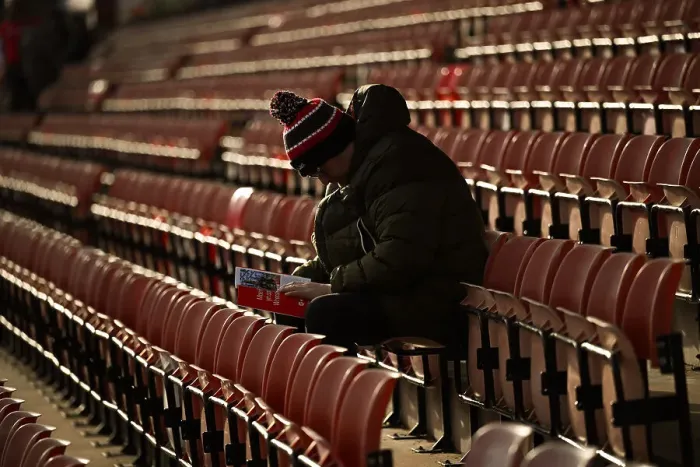 Framed Print : Welcome to Wrexham AFC - an early fan sitting reading the clubs programme hours before the game
