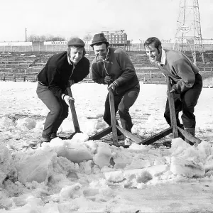Bolton Wanderers players clear the snow from the pitch at Burnden Park Bolton Wanderers players clear the snow from the pitch at Burnden Park