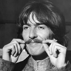 George Harrison tweaks his moustache at EMI studios for rehearsa