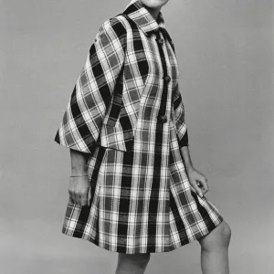 Model wearing large hat and checked coat