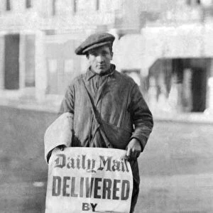A newspaper boy with a sign