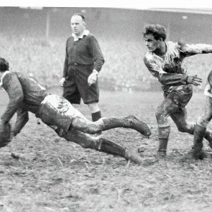 Rex Willis the Welsh scrum half, dives in getting the ball back to his partner Cliff Morgan Rex Willis the Welsh scrum half, dives in getting the ball back to his partner Cliff Morgan