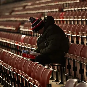 Welcome to Wrexham AFC - an early fan sitting reading the clubs programme hours before the game Welcome to Wrexham AFC - an early fan sitting reading the clubs programme hours before the game