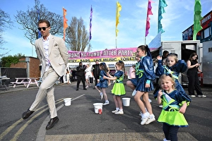 Soul Of Sport Prints: 2025 Grand National Aintree a race goer dances with children outside Aintree after racing on the Friday