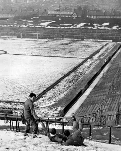 Crystal Palace footballers sliding down the snowy slope at the Selhurst Park ground