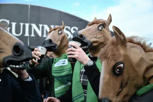 Racing Prints: Fans get in the Cheltenham mood by sipping on their pints of Guinness while wearing a horse mask Cheltenham Festival