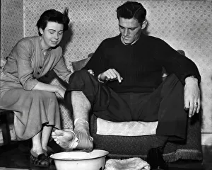 Manchester City FC Prints: Manchester City footballer Bill Leivers soaking his injured foot in a bowl of water prepared by his wife