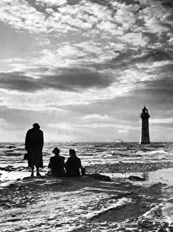 New Brighton Lighthouse, with silhouetted figures watching