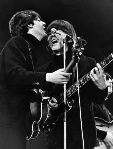 Sixties Prints: Paul McCartney and George Harrison share a microphone on stage